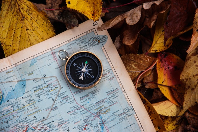 A compass on the corner of a paper map.